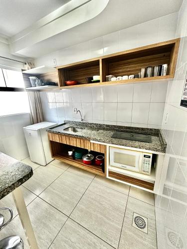 a kitchen with a counter and a microwave at Lacqua diRoma - Hotel e Parque Aquático in Caldas Novas