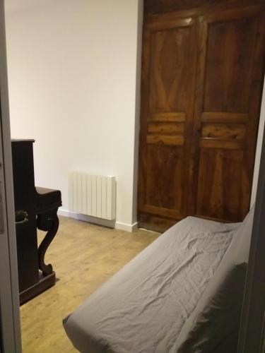 une chambre avec un piano, un lit et un placard dans l'établissement Location T3 Centre ville avec parking, à Esquièze - Sère