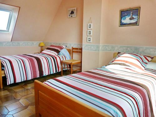 a bedroom with two beds and a chair at 605 VIlla ocean Atlantique au bout du jardin in Audierne