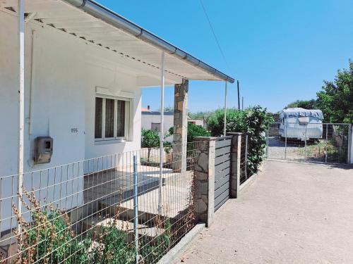 a fence on the side of a white house at SUN and Sea HOUSE Kavala ammolofoi αμμόλοφοι in Eleftheres