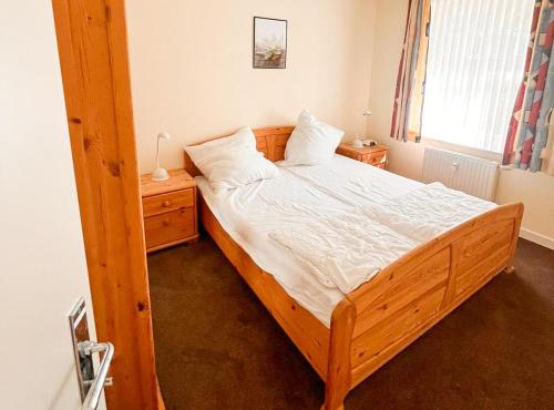 a bedroom with a large wooden bed and a window at Ostseewelle 5 in Kühlungsborn