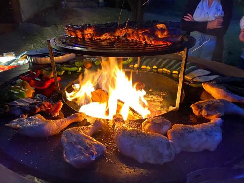 un foyer avec de la viande et de la nourriture dessus dans l'établissement Camping La Châtaigneraie, à Gravières