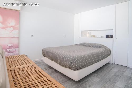a bedroom with a bed in a white room at Season Apartments in Sesimbra