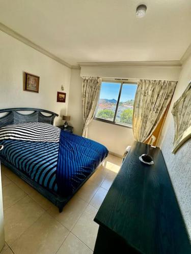 une chambre avec un lit bleu et une fenêtre dans l'établissement 14468 deux pièces avec piscine, à Mandelieu-la-Napoule