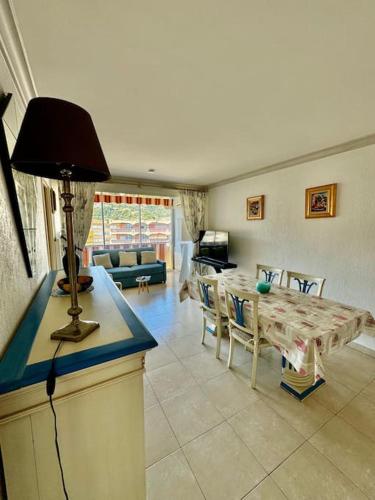 un salon avec une table et un canapé dans l'établissement 14468 deux pièces avec piscine, à Mandelieu-la-Napoule