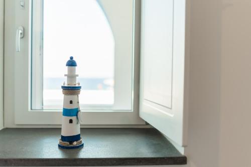 a lighthouse figurine sitting in front of a window at Archi Suite Canneto in Canneto