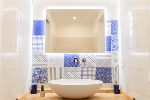 a bathroom with a white tub and blue and white tiles at Archi Suite Canneto in Canneto