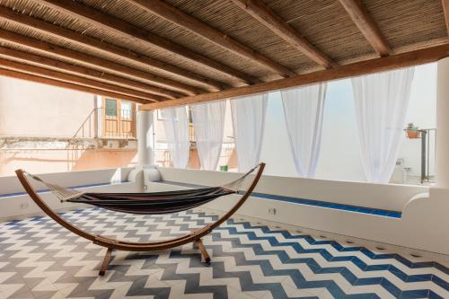 a hammock in a room with a large window at Archi Suite Canneto in Canneto