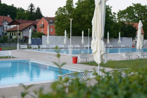 a swimming pool with a bunch of umbrellas and chairs at Studio apartment Old Town Castle in Samobor