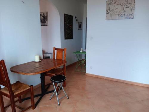 a dining room with a wooden table and chairs at appartement T2 tout confort in Bastia