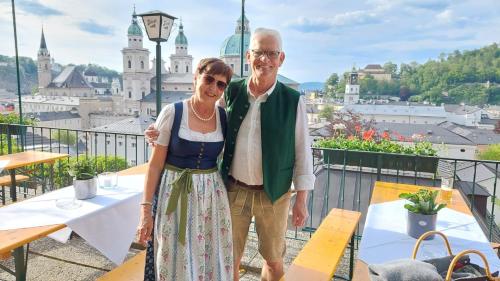 an older man and woman standing on a balcony with a view at Anna's Home - Ferienwohnungen in Ratsch an der Weinstraße