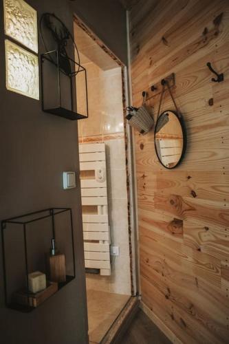 Cette chambre est dotée d'un mur en bois avec un miroir. dans l'établissement Petite maison cosy Chez Georges, à Auxonne
