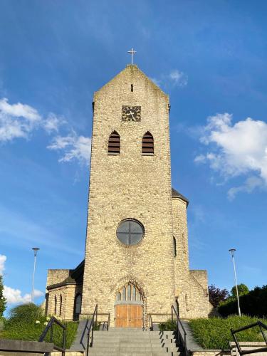 a building with a tower with a clock on it at Camping La Dolce Vita in Ransdaal