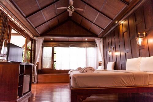 a bedroom with two beds and a ceiling fan at Coco Palm Beach Resort - SHA Extra Plus in Mae Nam