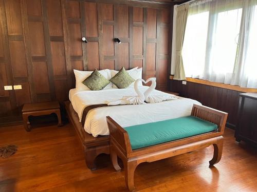 a bedroom with a bed with swans on it at Coco Palm Beach Resort - SHA Extra Plus in Mae Nam