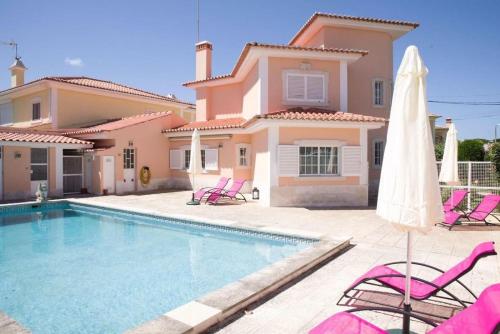 a villa with a swimming pool in front of a house at Lavanda Village Cascais - Villa Flamingo in Cascais
