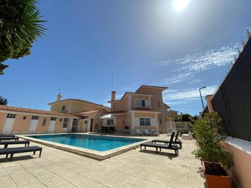 a villa with a swimming pool in front of a house at Lavanda Village Cascais - Villa Flamingo in Cascais