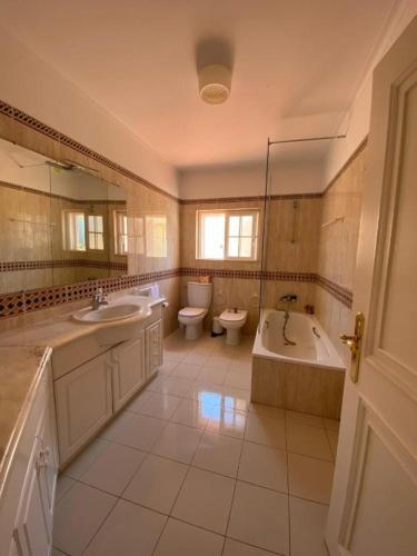 a bathroom with two sinks and a tub and a toilet at Lavanda Village Cascais - Villa Flamingo in Cascais