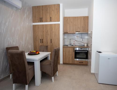 a kitchen with a white table and chairs and a counter at Apartmani Milos - Meljine in Herceg-Novi