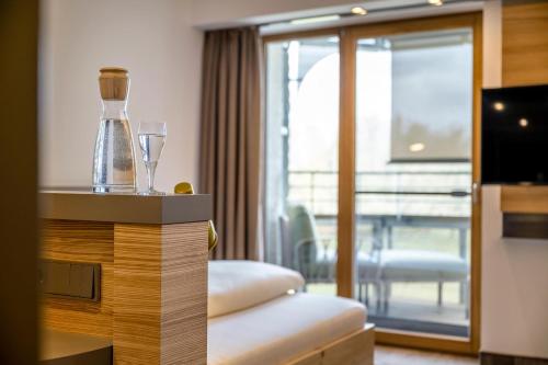a hotel room with a bottle and a wine glass at Hotel FrechDachs in Bad Füssing
