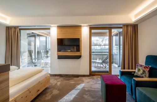 a hotel room with a couch and a tv at Hotel FrechDachs in Bad Füssing