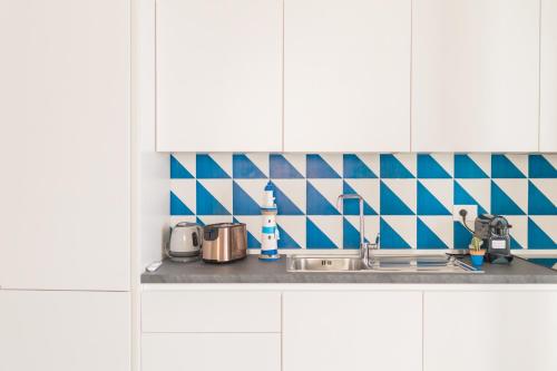 a kitchen counter with a sink and blue and white tiles at Archi Suite Canneto in Canneto