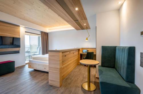 a bedroom with a bed and a table and a chair at Hotel FrechDachs in Bad Füssing