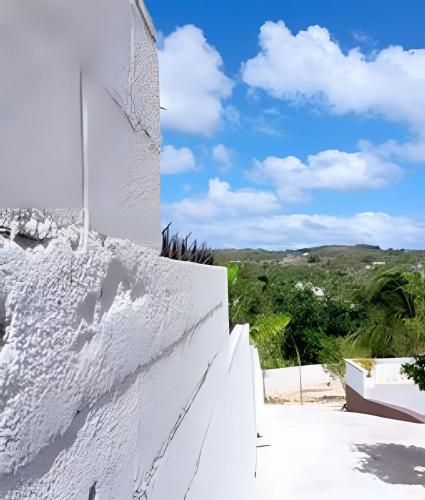 a white wall and stairs with a blue sky at Apart hotel Costa Verde #3 Exclusivo y Seguro in Santa Bárbara de Samaná
