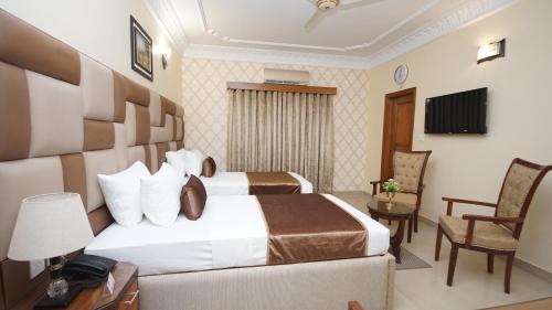 a hotel room with a large bed and a chair at World Inn by WI Hotel in Karachi