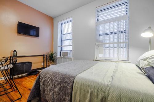 Un dormitorio con una cama y un televisor de pantalla plana. en Park Side Living, Get Cozy!, en Nueva York