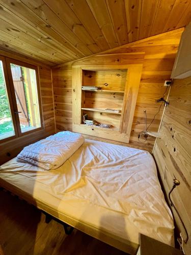 - un lit dans une chambre en bois dans une cabine dans l'établissement Chalet dans la verdure - Les Chapeliers, à Uvernet