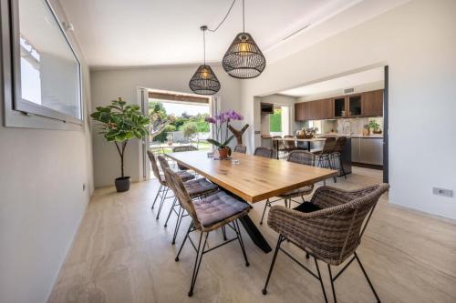une cuisine et une salle à manger avec une table et des chaises en bois dans l'établissement 06AK1 - Villa 4 bedrooms swimming pool and sauna, à Villeneuve-Loubet