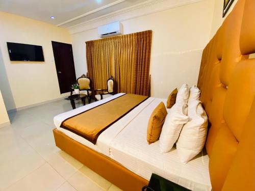 a bedroom with a large bed with two pillows at World Inn by WI Hotel in Karachi