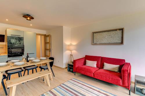 un salon avec un canapé rouge et une table dans l'établissement Apartment Cristal des Glaces, Mont Blanc View, Alpes Travel, sleeps 6, à Chamonix-Mont-Blanc