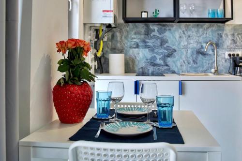a table with wine glasses and a vase with flowers at Bulldog Studio in Năvodari
