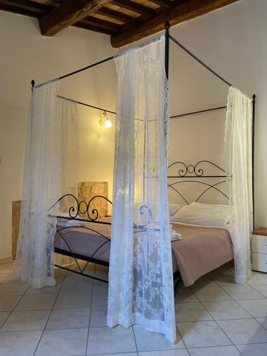 ein Schlafzimmer mit Himmelbett und weißen Vorhängen in der Unterkunft Affittacamere A Modo Mio in Foligno