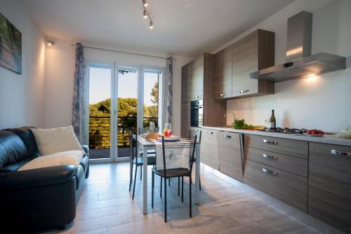 Una cocina con una mesa y un sofá en una habitación. en Appartamenti Residence Giardini CENTRALISSIMO AL MARE, en Riccione