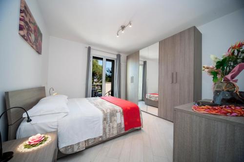 Un dormitorio con una cama y una mesa con flores. en Appartamenti Residence Giardini en Riccione
