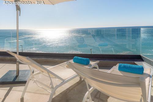two chairs sitting in front of a large window at Season Apartments in Sesimbra
