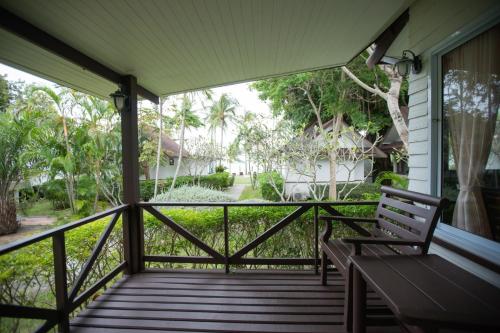 a porch with a bench and a view of a yard at Coco Palm Beach Resort - SHA Extra Plus in Mae Nam