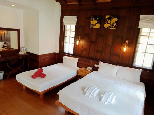 a bedroom with two beds with white sheets and red pillows at Coco Palm Beach Resort - SHA Extra Plus in Mae Nam