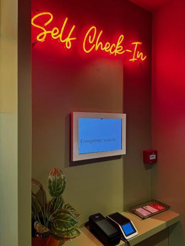 a sign that saysel check in on a wall at Tourist Inn One Amsterdam in Amsterdam