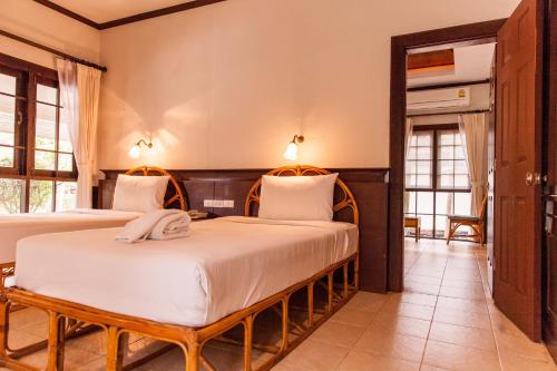 a bedroom with two beds in a room at Coco Palm Beach Resort - SHA Extra Plus in Mae Nam