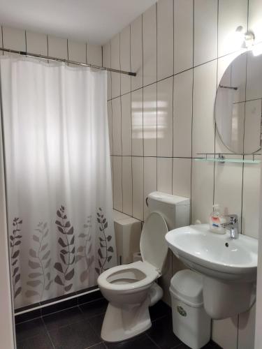 a white bathroom with a toilet and a sink at Vila Marius 2 Mai in 2 Mai