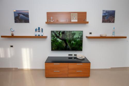 a living room with a tv on a white wall at Maver apartment in Mali Lošinj