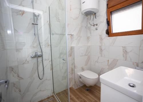 a bathroom with a shower and a toilet and a sink at Apartmani Milos - Meljine in Herceg-Novi