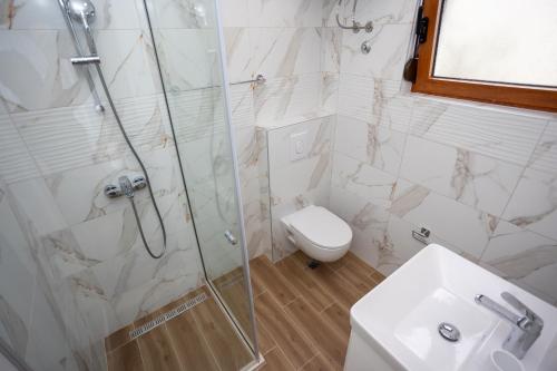 a bathroom with a shower and a toilet and a sink at Apartmani Milos - Meljine in Herceg-Novi