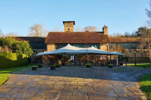 a building with a large umbrella in front of it at Coworth Park - Dorchester Collection in Ascot