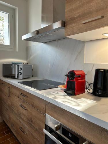 une cuisine avec un appareil rouge sur un comptoir dans l'établissement Sublime maison de montagne, à Guillaumes