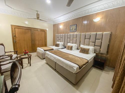 a hotel room with two beds and a chair at World Inn by WI Hotel in Karachi